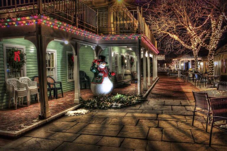 Picture of aHoliday scene with a snowman on a front porch